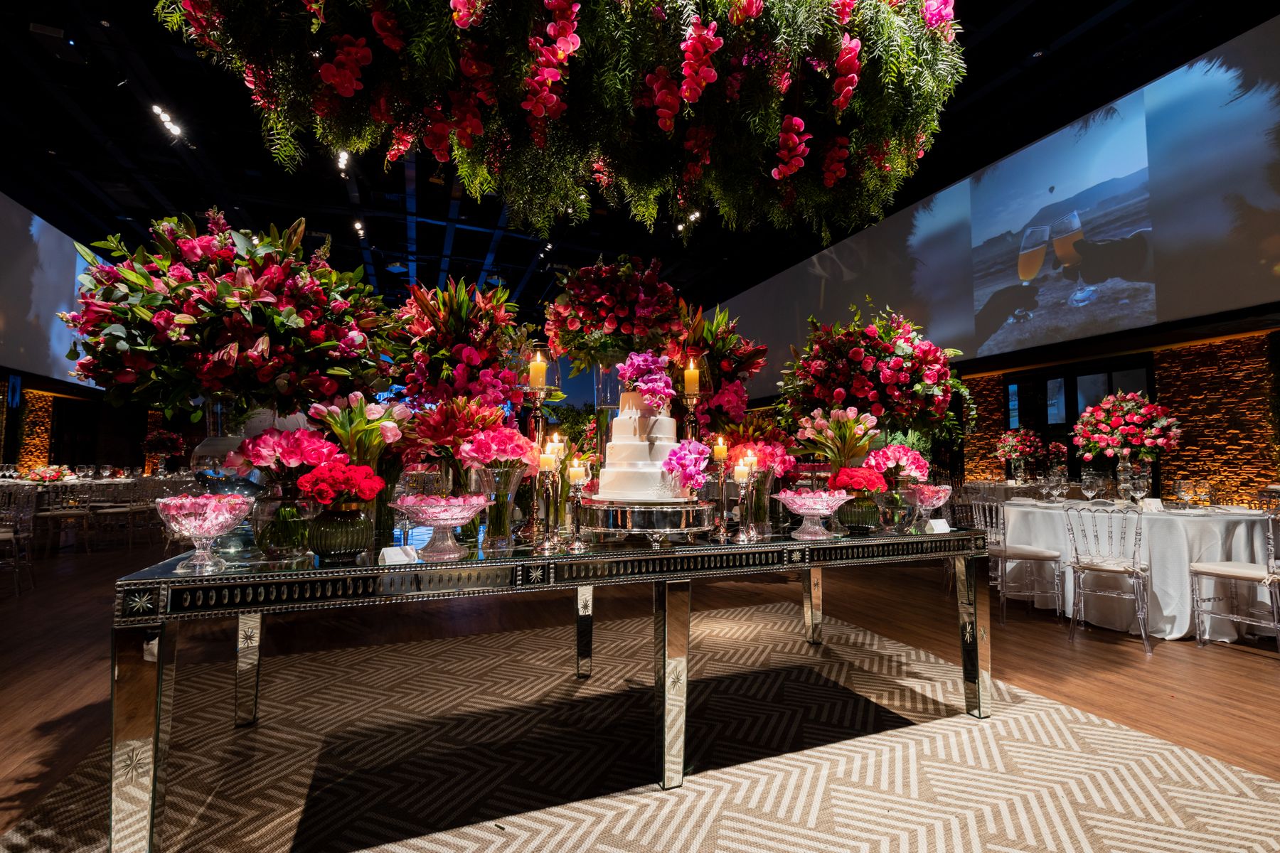 Wedding reception with sculptural pink florals, candlelight and a decorated cake table